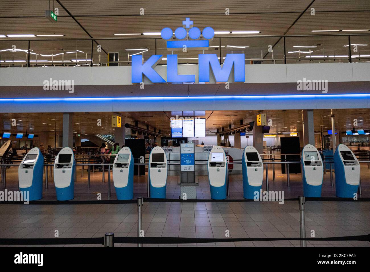 KLM-Check-in-Schalter, Check-in-Automaten im Terminal des internationalen Flughafens Amsterdam Schiphol während der Pandemie Covid-19. Die Anzahl der Passagiere und die Crew tragen Schutzausrüstung wie die obligatorischen Gesichtsmasken und Handschuhe, um die Ausbreitung des Coronavirus zu vermeiden. Die Zahl der Passagiere im Weltflug sank aufgrund der Reisebeschränkungen, Sicherheitsmaßnahmen wie Sperren, Quarantäne, PCR und Schnelltests vor den Flügen während der Ära der Coronavirus-Pandemie Covid-19, die die Luft- und Reisebranche schwer getroffen hatte. Am Stockfoto