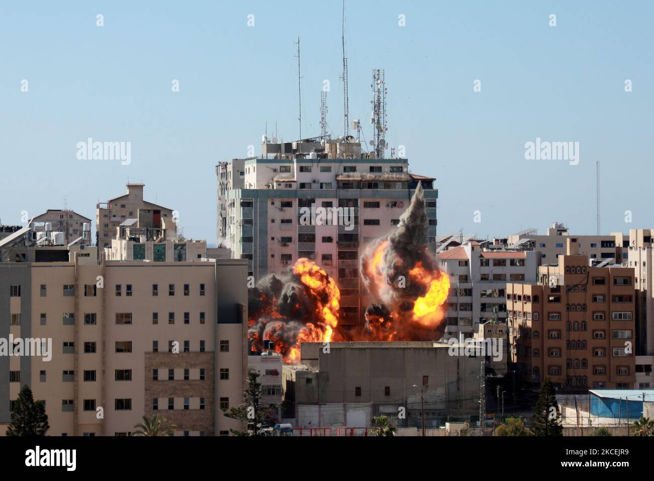 Am 15. Mai 2021 bricht aus dem Jala-Turm ein Feuerball aus, der bei einem israelischen Luftangriff in Gaza-Stadt zerstört wird, der von der palästinensischen Hamas-Bewegung kontrolliert wird. - Israelische Luftangriffe schlugen den Gazastreifen ein, töteten 10 Mitglieder einer Großfamilie und zerstörten ein wichtiges Mediengebäude, während palästinensische Kämpfer im Gegenzug unter Gewalt im Westjordanland Raketen abfeuerten. Die israelische Luftwaffe zielte auf den 13-stöckigen Jala Tower, in dem das in Katar ansässige Al-Jazeera-Fernsehen und die Nachrichtenagentur Associated Press untergebracht sind. (Foto von Majdi Fathi/NurPhoto) Stockfoto