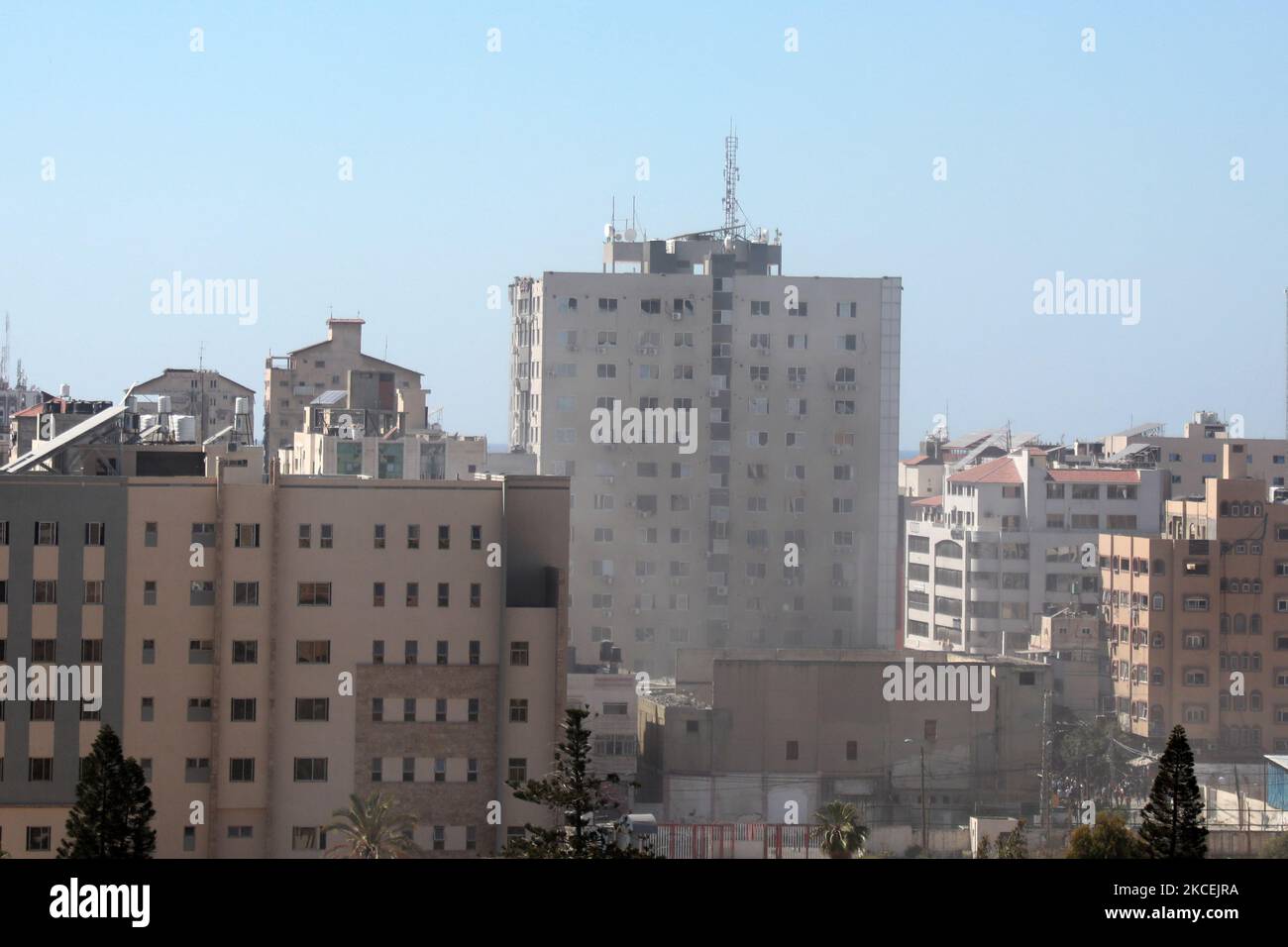 Eine dicke Rauchsäule steigt vom Jala-Turm auf, als er am 15. Mai 2021 bei einem israelischen Luftangriff in Gaza-Stadt, der von der palästinensischen Hamas-Bewegung kontrolliert wird, zerstört wird. - Israelische Luftangriffe schlugen den Gazastreifen ein, töteten 10 Mitglieder einer Großfamilie und zerstörten ein wichtiges Mediengebäude, während palästinensische Kämpfer im Gegenzug unter Gewalt im Westjordanland Raketen abfeuerten. Die israelische Luftwaffe zielte auf den 13-stöckigen Jala Tower, in dem das in Katar ansässige Al-Jazeera-Fernsehen und die Nachrichtenagentur Associated Press untergebracht sind. (Foto von Majdi Fathi/NurPhoto) Stockfoto