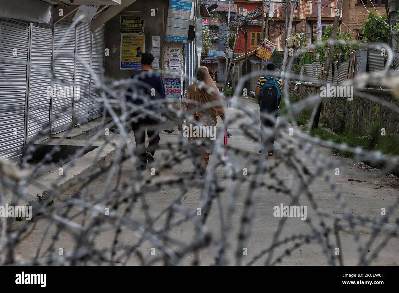 Kashmiris laufen am 18. Mai 2021 an dem von der indischen Regierung verlegten Stacheldraht vorbei, um die öffentliche Bewegung während der COVID-19 Corona Curfew in Baramulla, Jammu und Kashmir, Indien, zu stoppen. Die Jammu- und Kaschmir-Regierung hatte am Samstag die Sperre bis zum 24. Mai verlängert. Die Beamten sagten, dass die Beschränkungen für die Bewegung und Versammlung von Menschen am Sonntag weiterhin in Kraft bleiben, obwohl die Einschränkungen nicht streng seien. (Foto von Nasir Kachroo/NurPhoto) Stockfoto