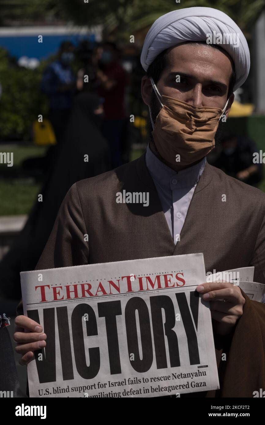 Ein iranischer Geistlicher hält eine Zeitung, während er am 22. Mai 2021 an einer Versammlung zur Unterstützung des palästinensischen Volkes auf dem Palästinenserplatz im Zentrum von Teheran teilnahm. Eine Gruppe iranischer Männer und Frauen haben sich auf dem Palästinenserplatz versammelt, um den Sieg der Palästinenser über Israel zu feiern, so die Erklärung, die von einem Protestierenden gelesen wurde. (Foto von Morteza Nikoubazl/NurPhoto) Stockfoto