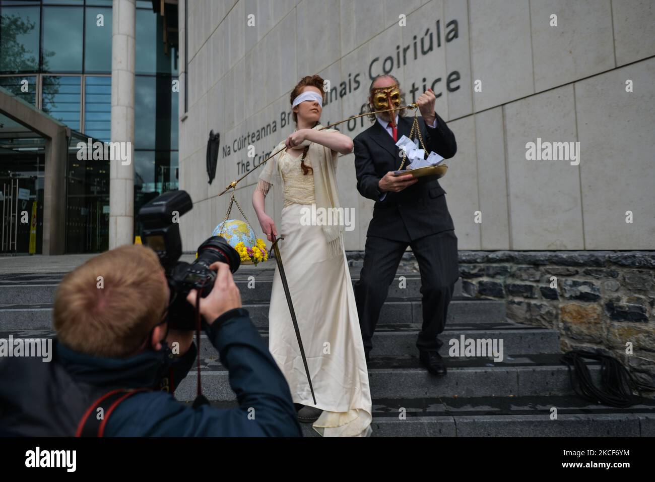 Die Aktivistinnen der Extinction Rebellion, Ceara Carney, kleiden sich mit verbundenen Augen in einem Kleid, während Lady Justice und Louis Heath einen Anzug tragen, um den Staat zu repräsentieren, der während eines theatralischen Protestes auf den Stufen des Strafgerichtshofs in Dublin gesehen wurde, um die Ungerechtigkeit der Klimauntätigkeit zu zeigen, wie die 20-jährige Orla Murphy, Ein Klimaaktivist erscheint vor Gericht wegen strafrechtlicher Schäden. Am Dienstag, den 25. Mai 2021, in Dublin, Irland. (Foto von Artur Widak/NurPhoto) Stockfoto