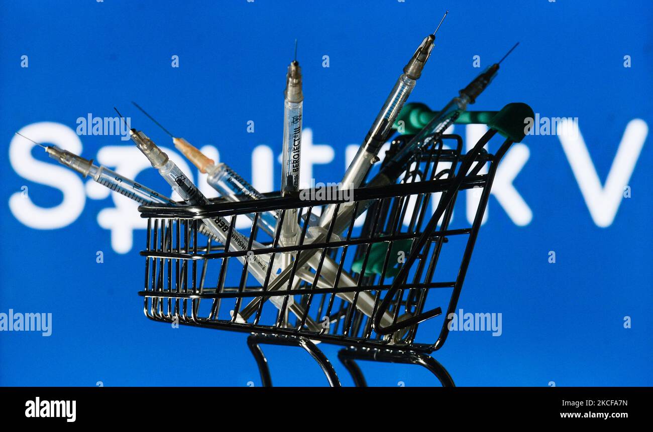 Medizinische Spritzen im Mini-Einkaufswagen sind vor dem Sputnik V-Logo auf einem Bildschirm zu sehen. Am Freitag, den 28. Mai 2021, in Dublin, Irland. (Foto von Artur Widak/NurPhoto) Stockfoto