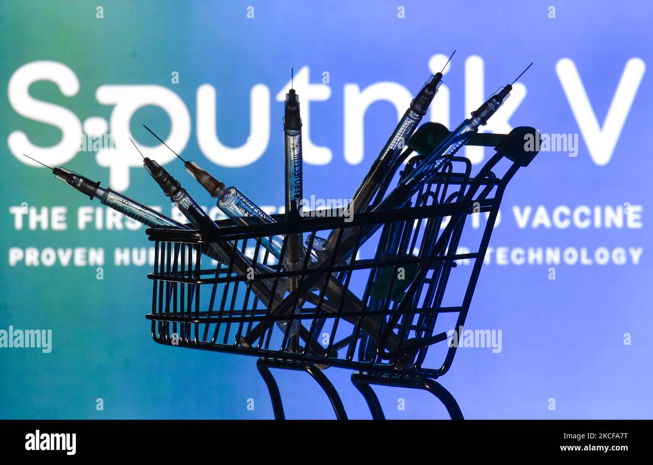 Medizinische Spritzen im Mini-Einkaufswagen sind vor dem Sputnik V-Logo auf einem Bildschirm zu sehen. Am Freitag, den 28. Mai 2021, in Dublin, Irland. (Foto von Artur Widak/NurPhoto) Stockfoto