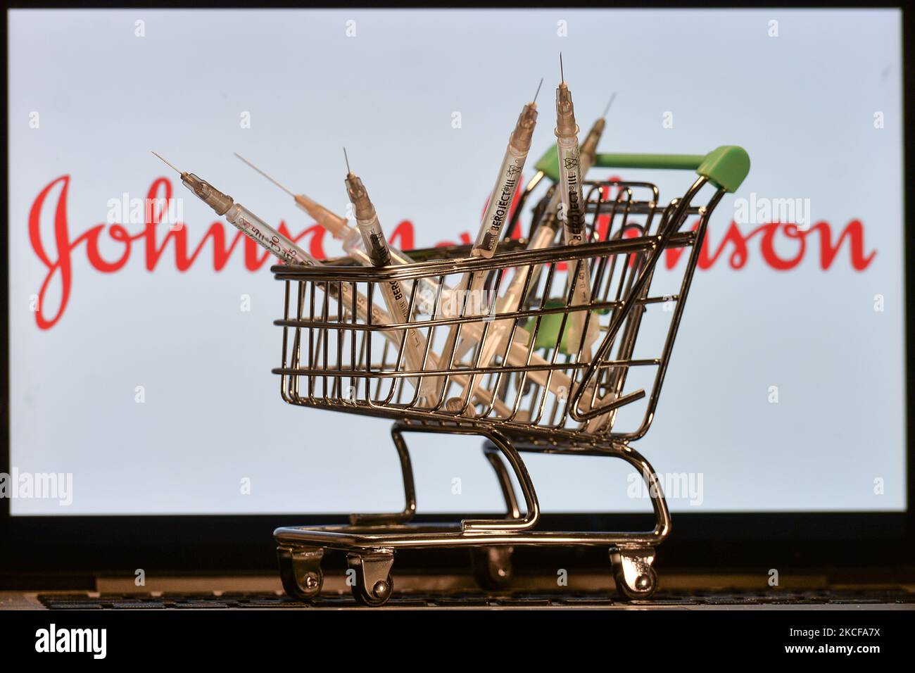 Medizinische Spritzen im Mini-Einkaufswagen sind vor dem Johnson and Johnson-Logo auf einem Bildschirm zu sehen. Am Freitag, den 28. Mai 2021, in Dublin, Irland. (Foto von Artur Widak/NurPhoto) Stockfoto