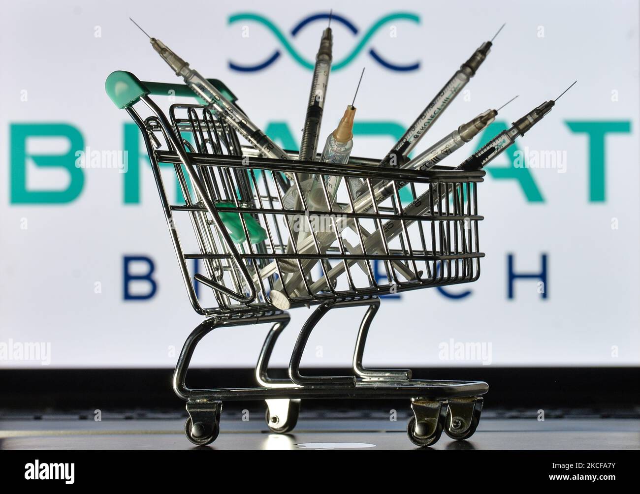 Medizinische Spritzen im Mini-Einkaufswagen sind vor dem Bharat Biotech-Logo auf einem Bildschirm zu sehen. Am Freitag, den 28. Mai 2021, in Dublin, Irland. (Foto von Artur Widak/NurPhoto) Stockfoto