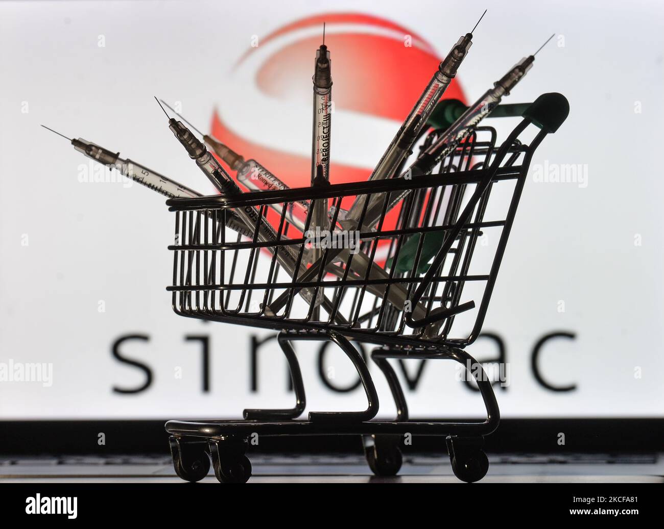 Medizinische Spritzen im Mini-Einkaufswagen sind vor dem Sinovac-Logo auf einem Bildschirm zu sehen. Am Freitag, den 28. Mai 2021, in Dublin, Irland. (Foto von Artur Widak/NurPhoto) Stockfoto