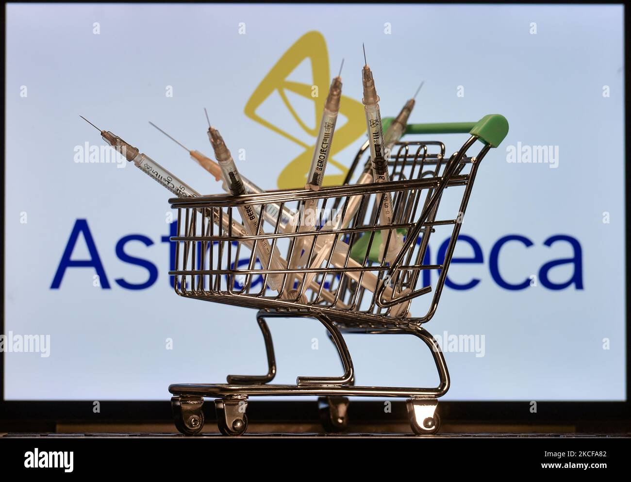 Medizinische Spritzen im Mini-Einkaufswagen sind vor dem AstraZeneca-Logo auf einem Bildschirm zu sehen. Am Freitag, den 28. Mai 2021, in Dublin, Irland. (Foto von Artur Widak/NurPhoto) Stockfoto