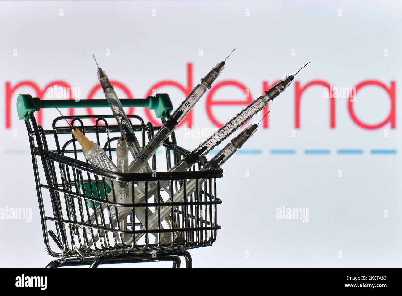 Medizinische Spritzen im Mini-Einkaufswagen sind vor dem Moderna-Logo auf einem Bildschirm zu sehen. Am Freitag, den 28. Mai 2021, in Dublin, Irland. (Foto von Artur Widak/NurPhoto) Stockfoto