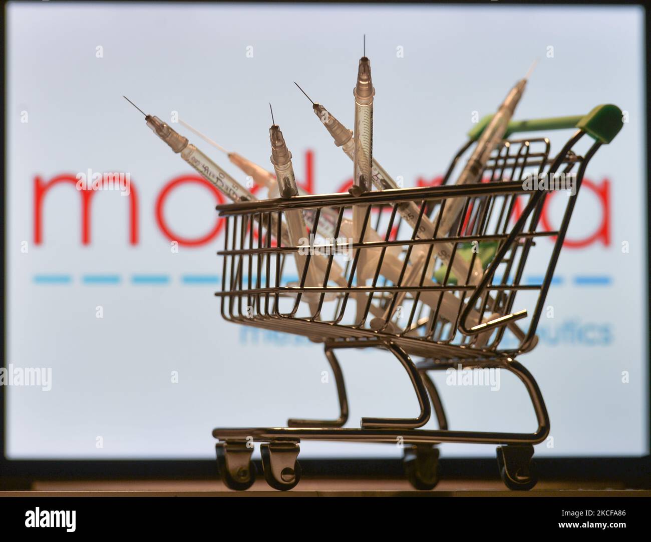 Medizinische Spritzen im Mini-Einkaufswagen sind vor dem Moderna-Logo auf einem Bildschirm zu sehen. Am Freitag, den 28. Mai 2021, in Dublin, Irland. (Foto von Artur Widak/NurPhoto) Stockfoto