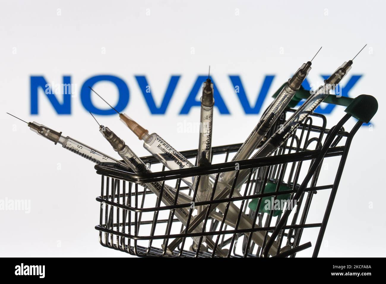 Medizinische Spritzen im Mini-Einkaufswagen sind vor dem Novavax-Logo auf einem Bildschirm zu sehen. Am Freitag, den 28. Mai 2021, in Dublin, Irland. (Foto von Artur Widak/NurPhoto) Stockfoto