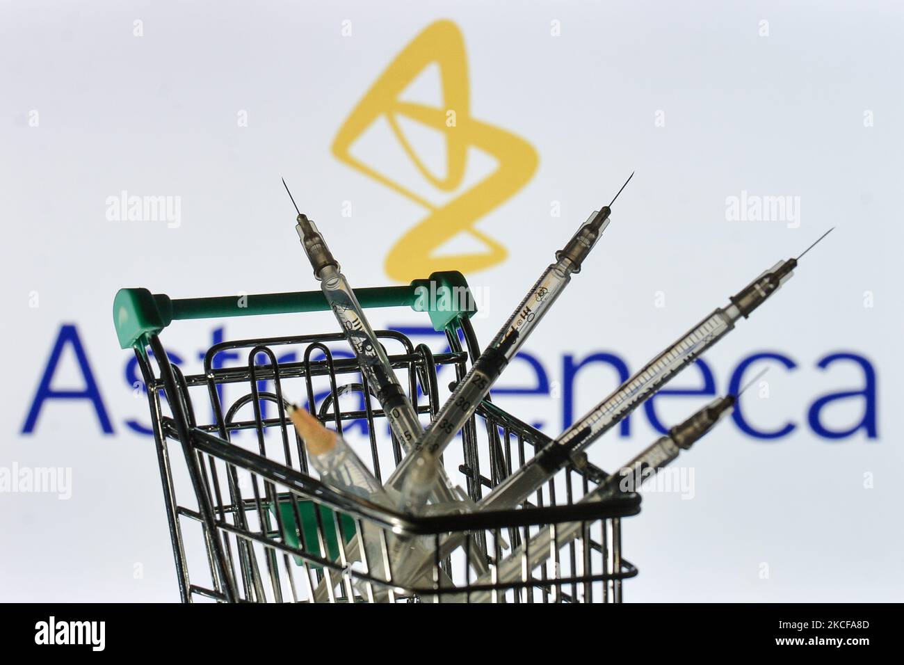 Medizinische Spritzen im Mini-Einkaufswagen sind vor dem AstraZeneca-Logo auf einem Bildschirm zu sehen. Am Freitag, den 28. Mai 2021, in Dublin, Irland. (Foto von Artur Widak/NurPhoto) Stockfoto
