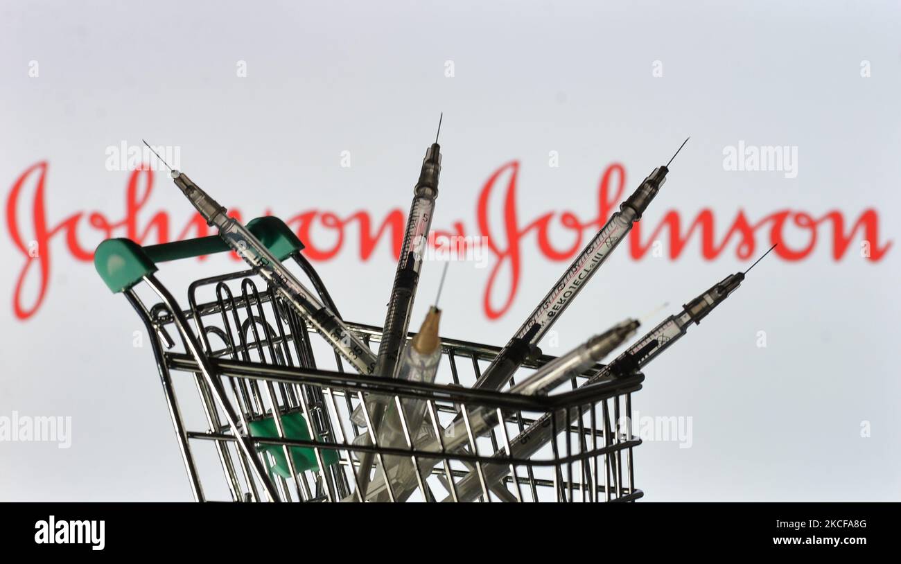 Medizinische Spritzen im Mini-Einkaufswagen sind vor dem Johnson and Johnson-Logo auf einem Bildschirm zu sehen. Am Freitag, den 28. Mai 2021, in Dublin, Irland. (Foto von Artur Widak/NurPhoto) Stockfoto
