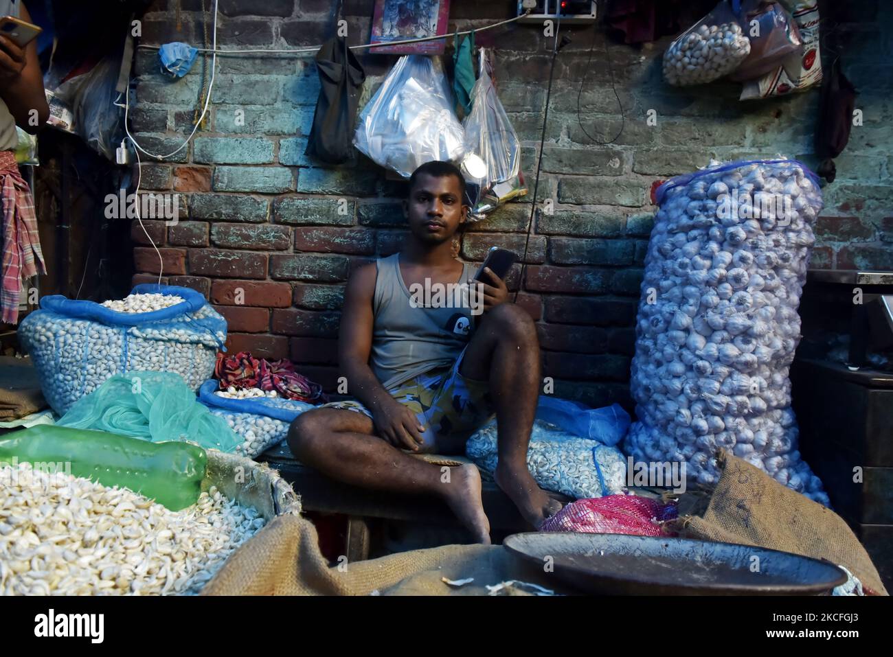 Ein Gemüseverkäufer schaut in die Kamera auf einem Gemüsemarkt in Kalkutta, Indien, 02. Juni 2021. Indien bereitet derzeit ein Konjunkturpaket für Sektoren vor, die am stärksten von einer tödlichen Coronavirus-Welle betroffen sind, und zielt darauf ab, eine Wirtschaft zu unterstützen, die mit einer Reihe örtlich begrenzter Sperrungen zu kämpfen hat, sagten Leute, die mit der Angelegenheit vertraut sind. Laut einem indischen Medienbericht arbeitet das Finanzministerium an Vorschlägen zur Stärkung der Tourismus-, Luftfahrt- und Gastgewerbe sowie kleiner und mittlerer Unternehmen. (Foto von Indranil Aditya/NurPhoto) Stockfoto