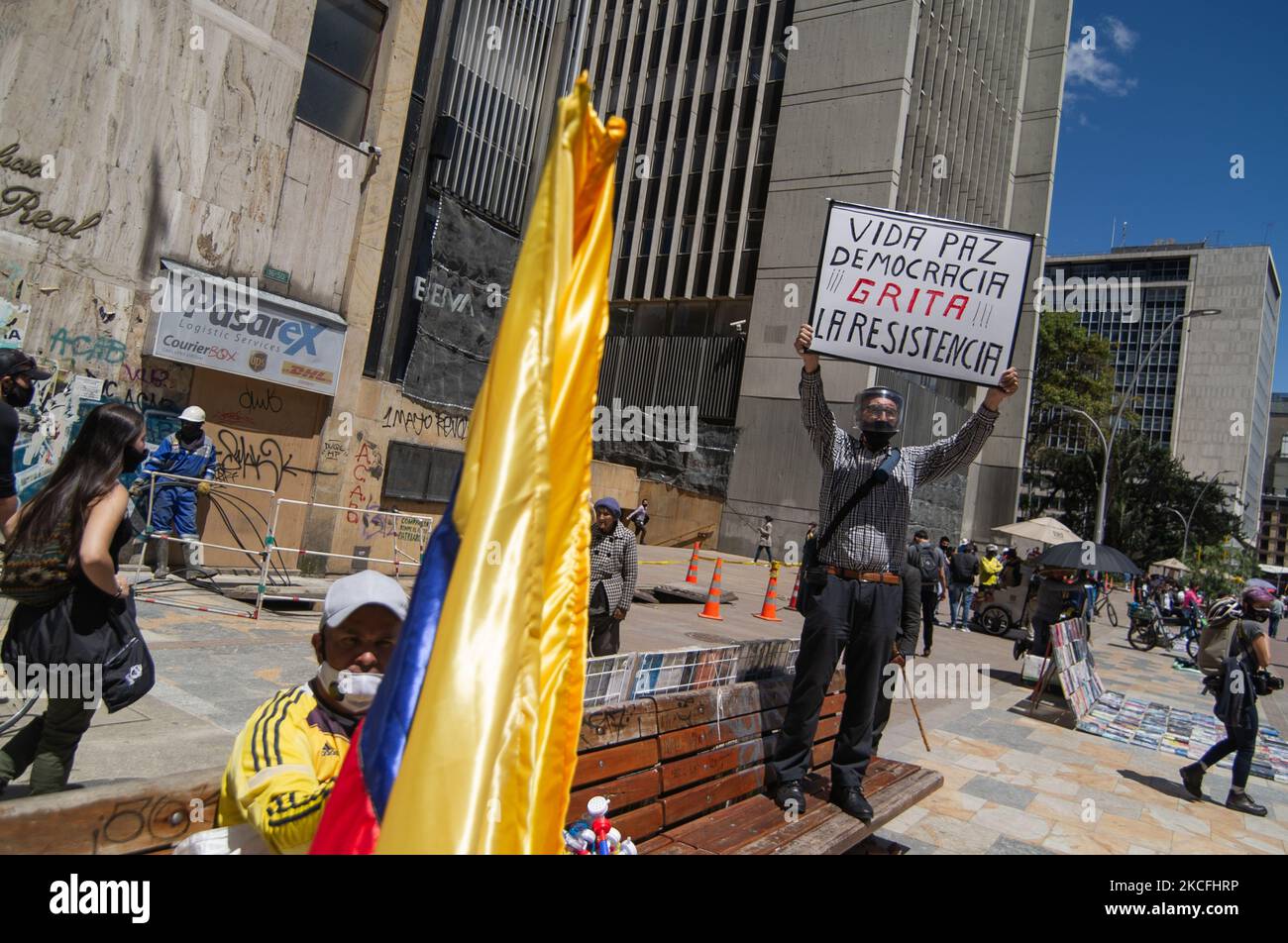 Ein Demonstrator hält ein Zeichen mit der Aufschrift „Leben, Frieden und Demokratie rufen nach dem Widerstand“, während ein anderer in der Innenstadt von Bogota eine kolumbianische Flagge hält, während sich die Menschen an der Plaza de Bolivar in 5 Wochen andauernder Anti-Regierung-Proteste gegen die Steuer- und Gesundheitsreformen von Präsident Ivan Duque sowie die Polizeibrutalität versammelten, die auf mindestens 60 Tote eskalierte Im vergangenen Monat aufgrund von Unruhen und Polizeibrutalität am 2. Juni 2021 in Bogota, Kolumbien. (Foto von Sebastian Barros/NurPhoto) Stockfoto