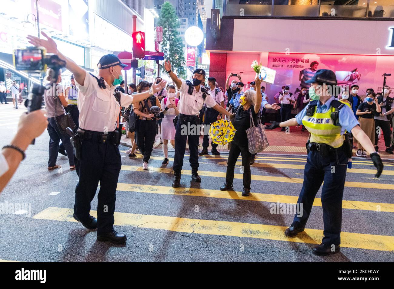 Polizeibeamte fordern 'Oma Wong' auf, die Straße nicht zu blockieren und in Richtung Victoria Park zu gehen. Am 4. Juni 2021 in Hongkong, China. (Foto von Marc Fernandes/NurPhoto) Stockfoto