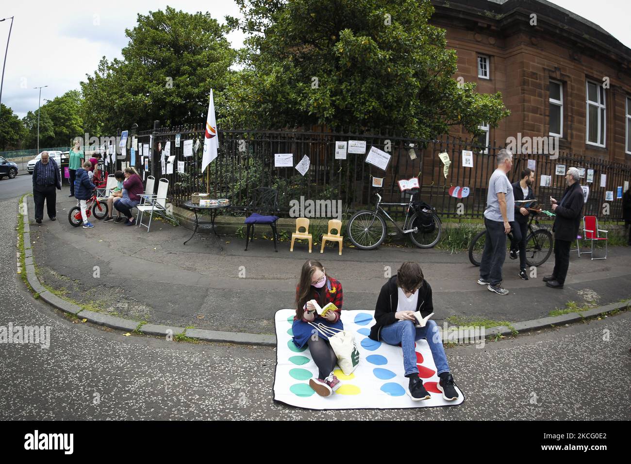 Demonstranten nehmen an einer Bibliothek Teil, die am 12. Juni 2021 in Glasgow, Schottland, vor der Whiteinch Library eingelesen wurde. Die Demonstranten demonstrieren gegen den Closer der Whiteinch Library, nachdem der gemeinderat Mitte April die geplante Schließung angekündigt hatte. Bisher hat die Kampagnengruppe „Save Whiteinch Library“ fast 4000 Unterschriften für ihre Petition gesammelt, die zur Wiedereröffnung der Whiteinch Library in ihrem ursprünglichen Zweckgebäude aufruft. (Foto von Ewan Bootman/NurPhoto) Stockfoto