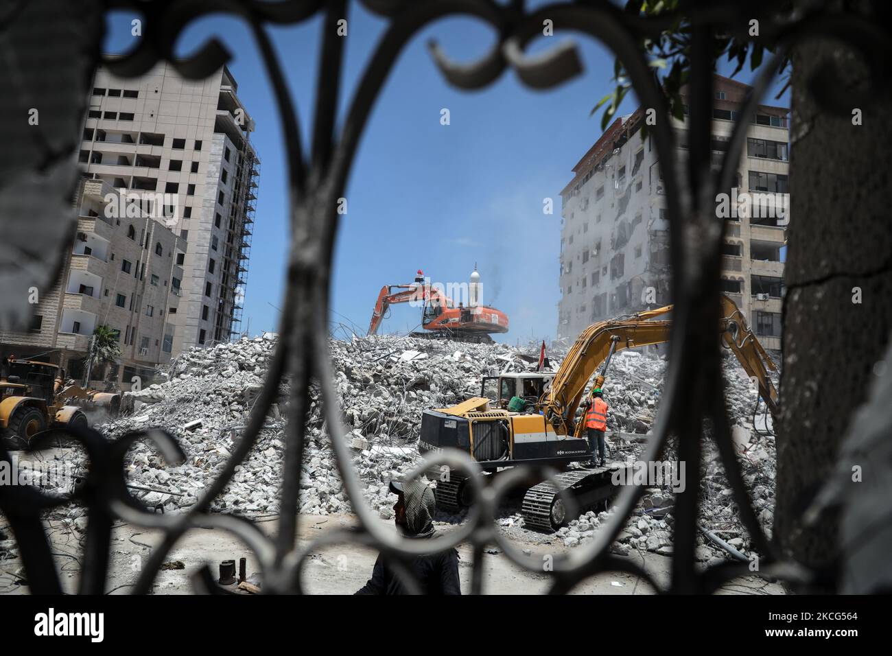 Palästinensische Arbeiter und ägyptische Bulldozer helfen am 16. Juni 2021 dabei, die Trümmer von Uildings zu beseitigen, die im vergangenen Monat durch israelische Luftangriffe zerstört wurden. - Nach der Vermittlung eines Waffenstillstands zwischen den Israelis und den Machthabern der Hamas im Gazastreifen, der Ägypten internationale diplomatische Schlagkraft erhielt, setzt Kairo nun auf ein $500-Millionen-Wiederaufbauprojekt, um seinen regionalen politischen Einfluss zu stärken. Im vergangenen Monat versprach Ägypten eine halbe Milliarde Dollar für den Wiederaufbau der blockierten palästinensischen Enklave, die 11 Tage lang von Israel während heftiger Kämpfe mit der Hamas bombardiert wurde, die mit einer ägyptischen Vermittlung endete Stockfoto