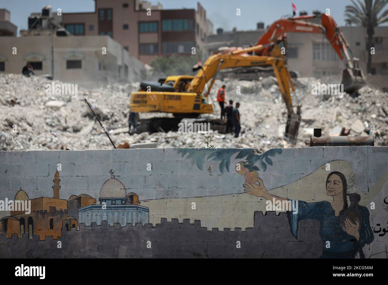 Palästinensische Arbeiter und ägyptische Bulldozer helfen am 16. Juni 2021 dabei, die Trümmer von Uildings zu beseitigen, die im vergangenen Monat durch israelische Luftangriffe zerstört wurden. - Nach der Vermittlung eines Waffenstillstands zwischen den Israelis und den Machthabern der Hamas im Gazastreifen, der Ägypten internationale diplomatische Schlagkraft erhielt, setzt Kairo nun auf ein $500-Millionen-Wiederaufbauprojekt, um seinen regionalen politischen Einfluss zu stärken. Im vergangenen Monat versprach Ägypten eine halbe Milliarde Dollar für den Wiederaufbau der blockierten palästinensischen Enklave, die 11 Tage lang von Israel während heftiger Kämpfe mit der Hamas bombardiert wurde, die mit einer ägyptischen Vermittlung endete Stockfoto