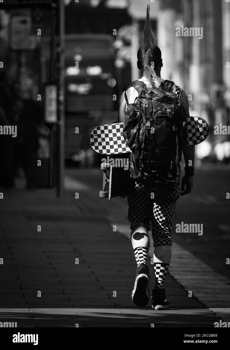Mann, der im Stadtzentrum von Dublin die Straße entlang läuft und zwei Skateboards trägt. Am Montag, den 21. Juni 2021, in Dublin, Irland. (Foto von Artur Widak/NurPhoto) Stockfoto