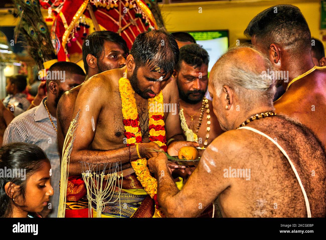 Tamilischer Hindu-Anhänger erhält Segen von einem Hindu-Priester, nachdem er das para-kavadi-Ritual (ein Ritual, bei dem er von Haken in seinen Rücken und seine Beine getrieben wird und beim Umkreisen des Tempels als Bußakt auf und ab prallte) während des Vinayagar Ther Thiruvizha Festivals in Ontario durchgeführt hat, Kanada am 23. Juli 2006. Die Gläubigen bereiten sich auf die Feier vor, indem sie sich 11 bis 25 Tage vor dem Fest durch Gebet, Zölibat und Fasten reinigen. Während dieses religiösen Festivals zeigen mehrere Anhänger ihre Hingabe, indem sie Opfer darbringen und ihre Körper mit Metallhaken und durchbohren Stockfoto