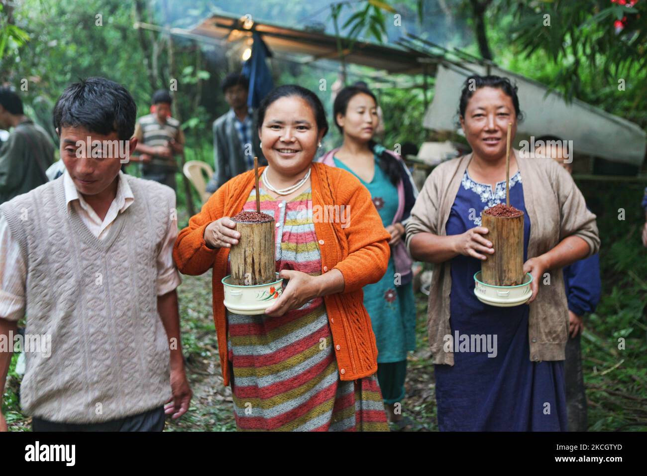 Lepcha-Frauen tragen traditionelles Hirsebier namens „che“, das sie den Dorfbewohnern während einer religiösen Zeremonie in ihrem kleinen Dorf tief im Dschungel in Sikkim, Indien, servieren werden. (Foto von Creative Touch Imaging Ltd./NurPhoto) Stockfoto