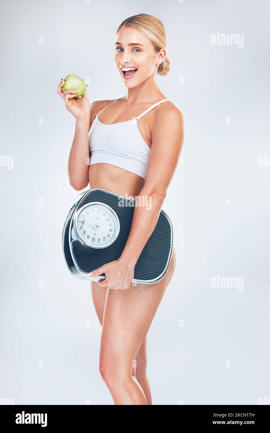 Apfel, Fitness und Frau mit einer Skala für den Fettabbau mit einer gesunden Ernährung nach dem Training, Bewegung und Training. Gewichtsverlust, Porträt und glückliches Mädchen Stockfoto