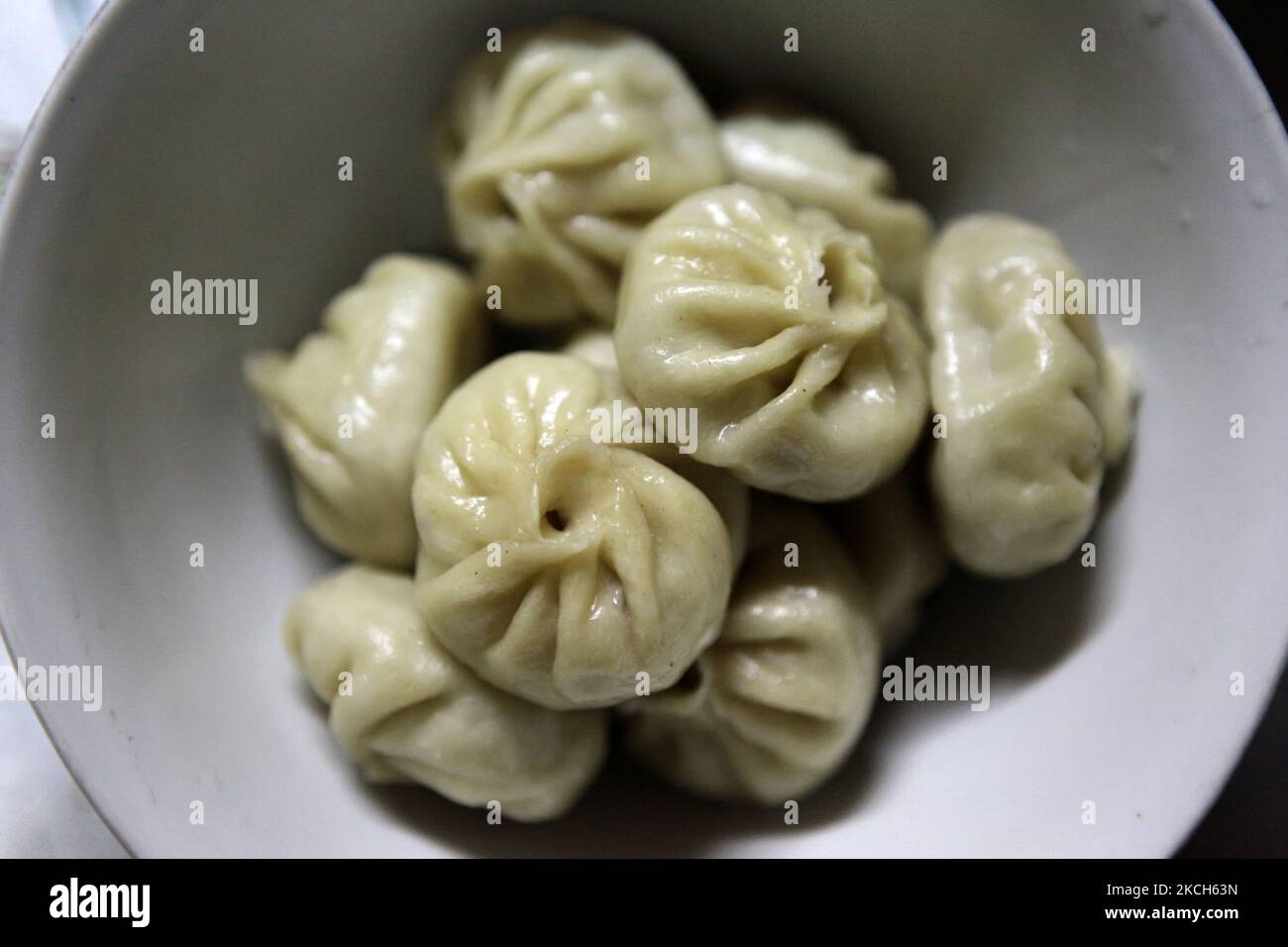 Momos in einer Schüssel in einem Restaurant in Darjeeling, Westbengalen, Indien, am 31. Mai 2010. Der Momo ist eine Art Knödel, die aus Tibet stammt. Sie ist in den nepalesischen Sherpas, Limbus, Gurungs und Magars beheimatet. Es wird in der Regel mit Yak-Fleisch gegessen. In Tibet, Bhutan, Sikkim, Nepal und Ladakh ist es zu einem traditionellen Essen geworden. Momos sind auch an Orten mit auffälliger nepalesischer Diaspora wie Himachal Pradesh, Westbengalen und Indiens nordöstlichen Staaten verbreitet und haben sich zu einem sehr beliebten Street Food in Nepal entwickelt. (Foto von Creative Touch Imaging Ltd./NurPhoto) Stockfoto