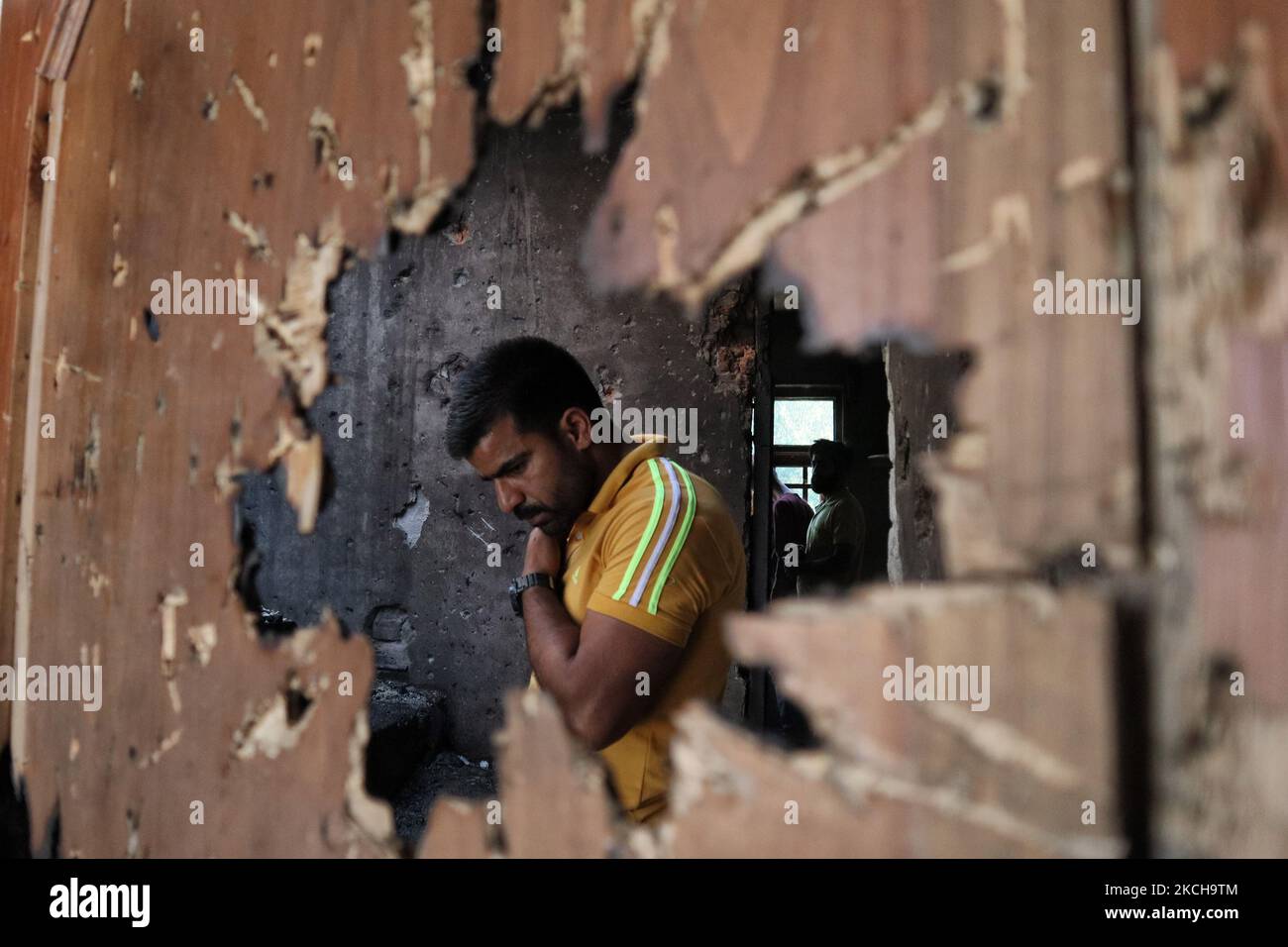 Kashmiri-Menschen bewerten das beschädigte Wohnhaus, in dem am 16. Juli 2021 bei einer Militäroperation in Srinagar, dem von Indien verwalteten Kaschmir, zwei Militante getötet wurden. Bei der Operation wurden zwei Kämpfer getötet und ein Wohnhaus beschädigt. (Foto von Muzamil Mattoo/NurPhoto) Stockfoto