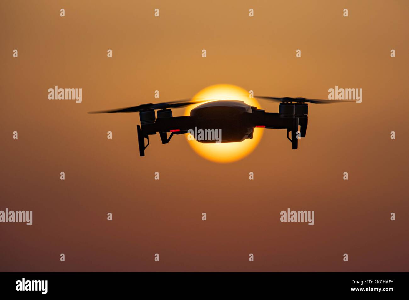 Eine Quadcopter-Drohne schwebt während eines Fluges vor der Sonne. Die fliegende Drohne wird als dunkle Silhouette gegen den spektakulären, farbenfrohen Sonnenuntergangshimmel und die Sonne gesehen, während die UAV in der Lage ist, Luftaufnahmen und Fotos über eine Fernbedienung aufzunehmen. Die spezifische Drohne ist eine DJI Mavic Air. Das unbemannte Luftfahrzeug ist bei Touristen beliebt, da die Technologie für jedermann in niedrigen Kosten zugänglich ist, aber auch viele professionelle Anwendungen hat Sani Beach Area, Chalkidiki, Griechenland am 15. Juli 2021 (Foto von Nicolas Economou/NurPhoto) Stockfoto