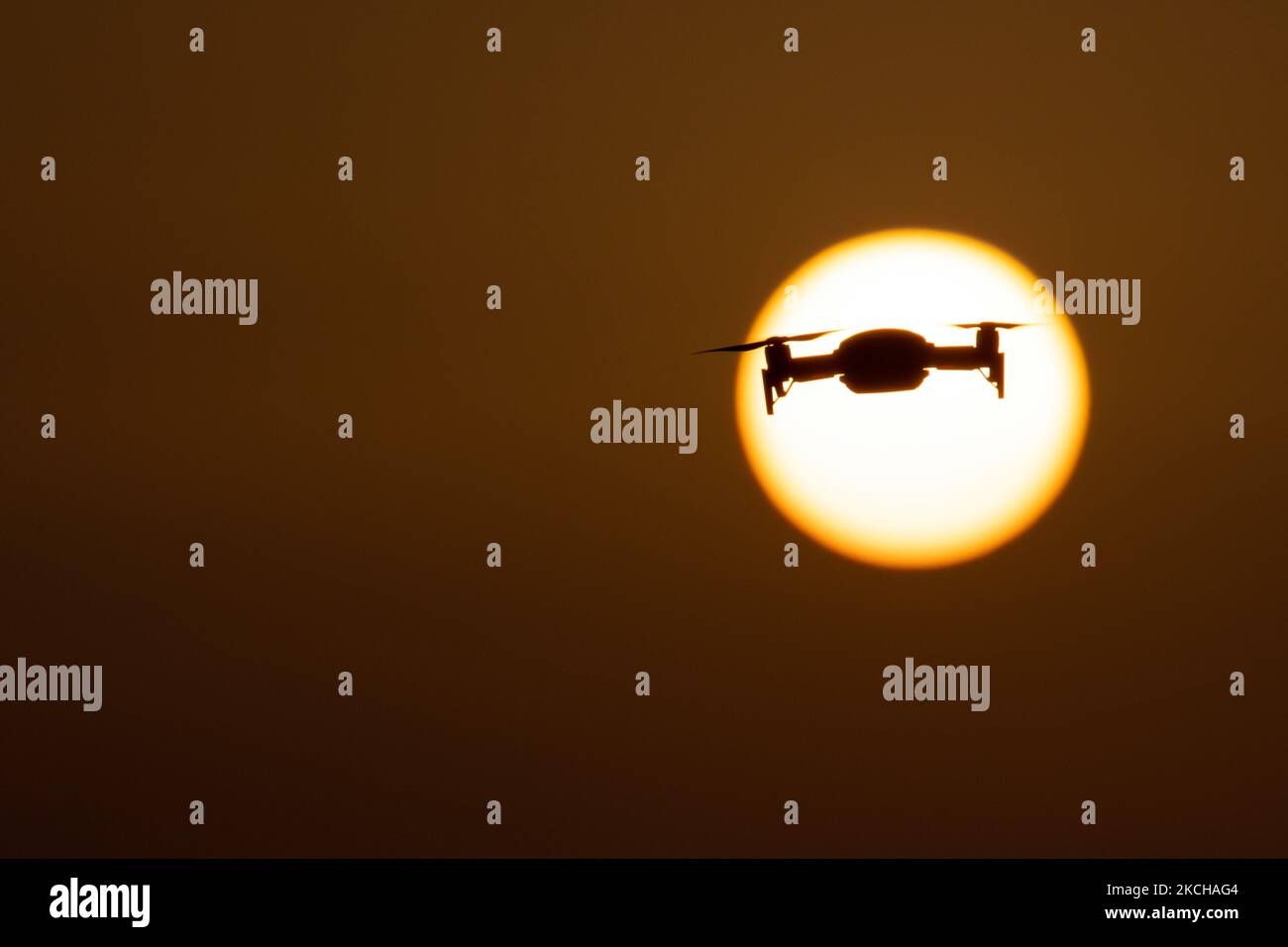 Eine Quadcopter-Drohne schwebt während eines Fluges vor der Sonne. Die fliegende Drohne wird als dunkle Silhouette gegen den spektakulären, farbenfrohen Sonnenuntergangshimmel und die Sonne gesehen, während die UAV in der Lage ist, Luftaufnahmen und Fotos über eine Fernbedienung aufzunehmen. Die spezifische Drohne ist eine DJI Mavic Air. Das unbemannte Luftfahrzeug ist bei Touristen beliebt, da die Technologie für jedermann in niedrigen Kosten zugänglich ist, aber auch viele professionelle Anwendungen hat Sani Beach Area, Chalkidiki, Griechenland am 15. Juli 2021 (Foto von Nicolas Economou/NurPhoto) Stockfoto