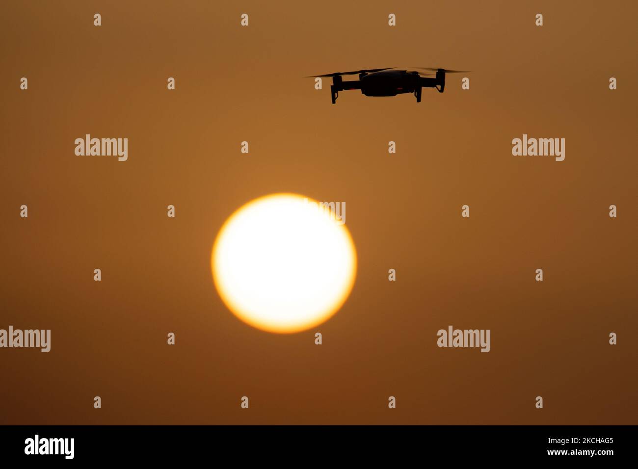 Eine Quadcopter-Drohne schwebt während eines Fluges vor der Sonne. Die fliegende Drohne wird als dunkle Silhouette gegen den spektakulären, farbenfrohen Sonnenuntergangshimmel und die Sonne gesehen, während die UAV in der Lage ist, Luftaufnahmen und Fotos über eine Fernbedienung aufzunehmen. Die spezifische Drohne ist eine DJI Mavic Air. Das unbemannte Luftfahrzeug ist bei Touristen beliebt, da die Technologie für jedermann in niedrigen Kosten zugänglich ist, aber auch viele professionelle Anwendungen hat Sani Beach Area, Chalkidiki, Griechenland am 15. Juli 2021 (Foto von Nicolas Economou/NurPhoto) Stockfoto