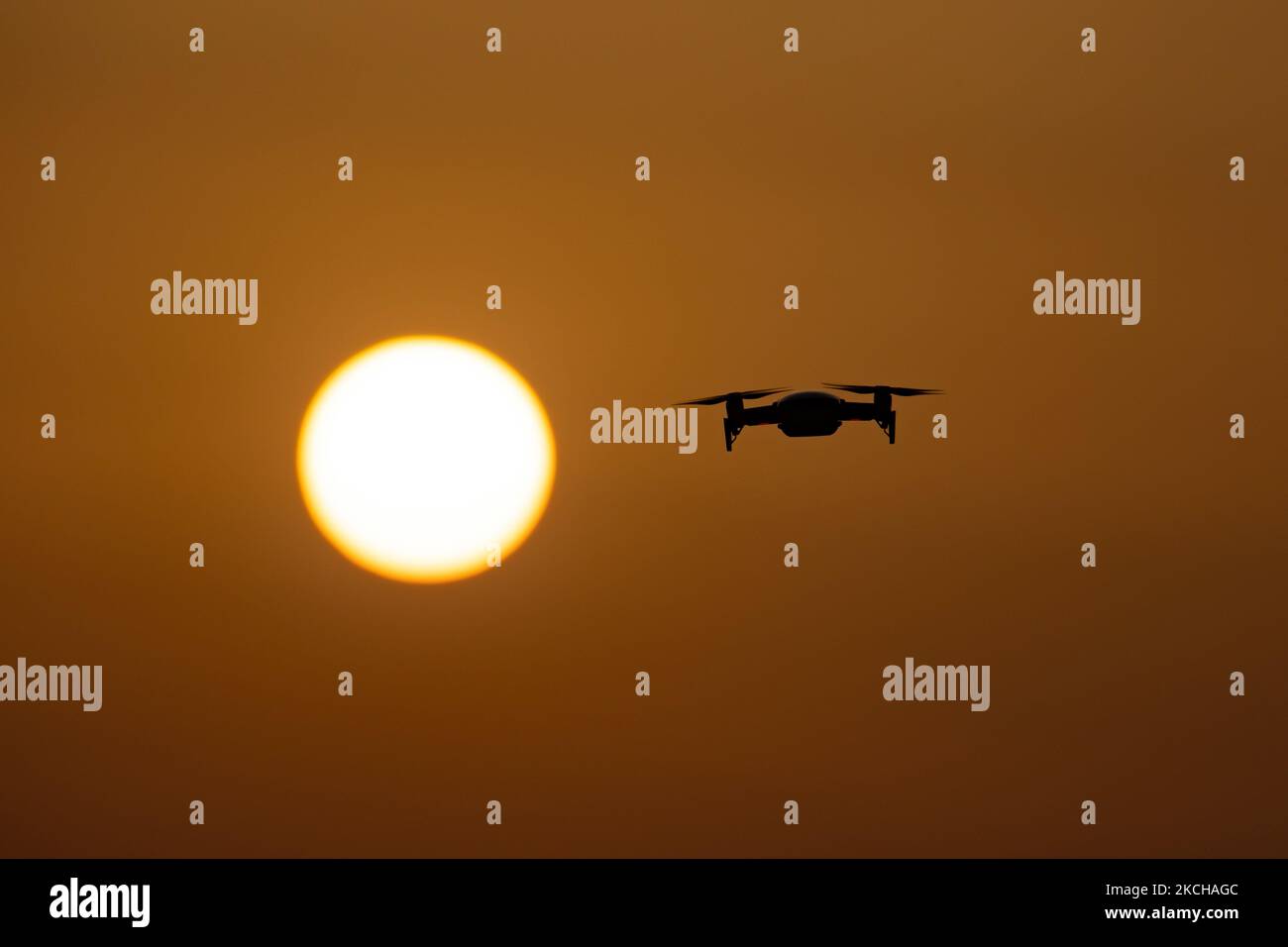 Eine Quadcopter-Drohne schwebt während eines Fluges vor der Sonne. Die fliegende Drohne wird als dunkle Silhouette gegen den spektakulären, farbenfrohen Sonnenuntergangshimmel und die Sonne gesehen, während die UAV in der Lage ist, Luftaufnahmen und Fotos über eine Fernbedienung aufzunehmen. Die spezifische Drohne ist eine DJI Mavic Air. Das unbemannte Luftfahrzeug ist bei Touristen beliebt, da die Technologie für jedermann in niedrigen Kosten zugänglich ist, aber auch viele professionelle Anwendungen hat Sani Beach Area, Chalkidiki, Griechenland am 15. Juli 2021 (Foto von Nicolas Economou/NurPhoto) Stockfoto