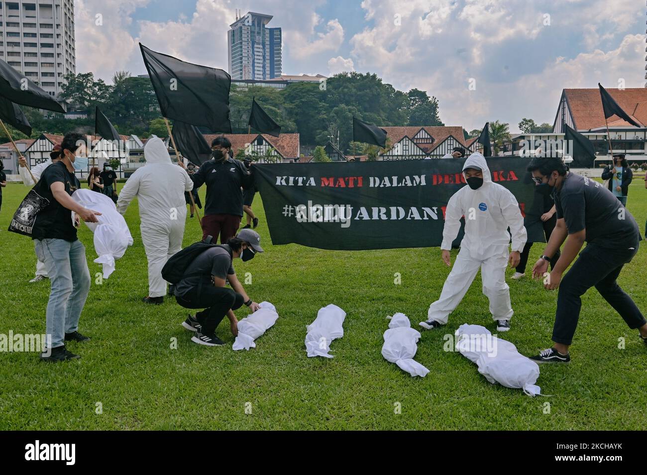 Demonstranten versammeln sich, als sie während eines Protestes unter schwarzer Flagge am 17. Juli 2021 in Kuala Lumpur, Malaysia, einen Scheinleichen auf den Boden legen. Der #BlackFlag Protestorganisator, der die malaysische Regierung nach dem Anstieg der positiven Fälle von Covid-19 als gescheiterte Regierung kritisierte, 13.215 Fälle am 15. Juli 2021, in denen der Rücktritt des Premierministers Muhyiddin Yassin gefordert wurde, eine vollständige Parlamentssitzung und ein automatisches Moratorium für alle Menschen (Foto von Zahim Mohd/NurPhoto) Stockfoto