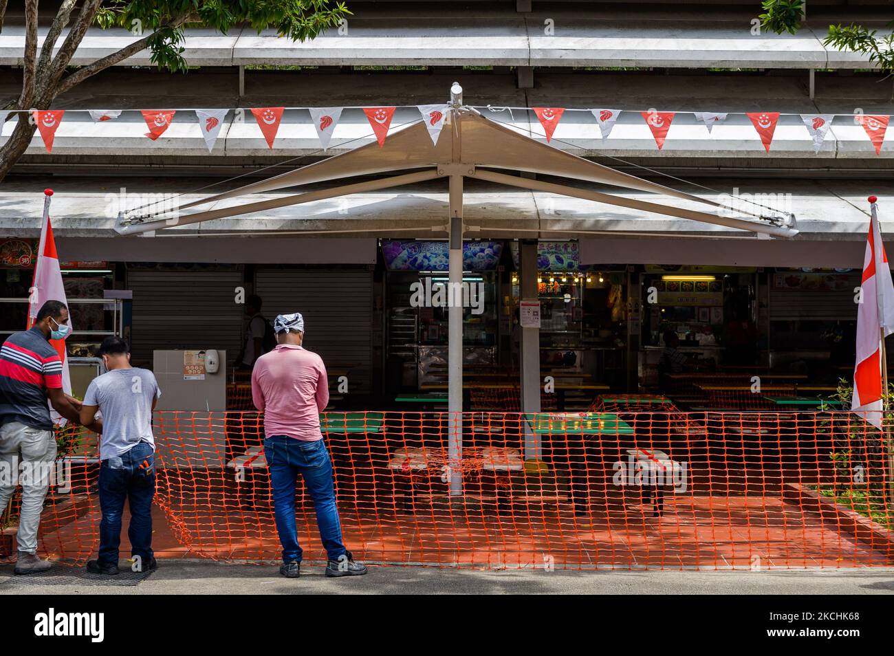 Am Samstag, den 24. Juli 2021, sperren Arbeiter den Eingang zu einem Lebensmittelzentrum in einer Wohnsiedlung in Singapur ab. Der Zugang zu den vielen Lebensmittelzentren, die von der Mehrheit der lokalen Bevölkerung Singapurs frequentiert werden, erfordert, dass Besucher das nationale elektronische Tracking-System nutzen, um wieder einzureisen. Das Essen in Restaurants ist von den Behörden nicht mehr erlaubt, da das Land seine Sperrmaßnahmen verstärkt hat, um gegen die steigenden Fälle des Covid-19-Virus, das aus seinem Hauptfischereihafen stammte und sich auf den Feuchtmärkten des Landes verbreitete, zu kämpfen. (Foto von Joseph Nair/NurPhoto) Stockfoto