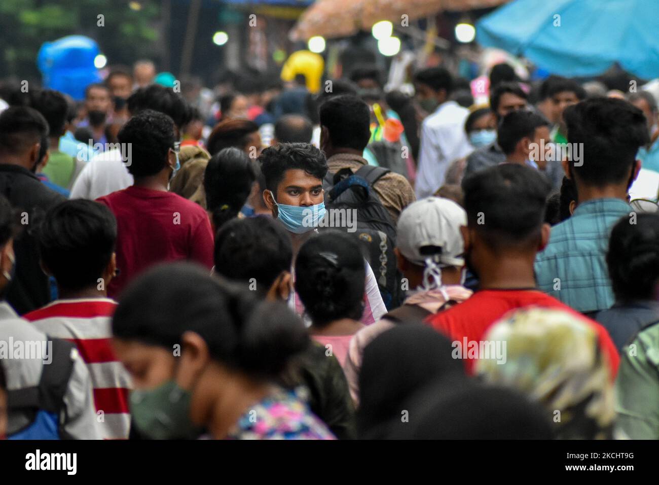 Ein Junge wird am 27. Juli 2021 in Kalkutta, Indien, unter verschiedenen Warnungen der Behörden vor einer wahrscheinlichen dritten Welle des COVID-19-Ausbruchs fälschlicherweise mit einer Maske auf einem geschäftigen Marktplatz gesehen. (Foto von Debarchan Chatterjee/NurPhoto) Stockfoto