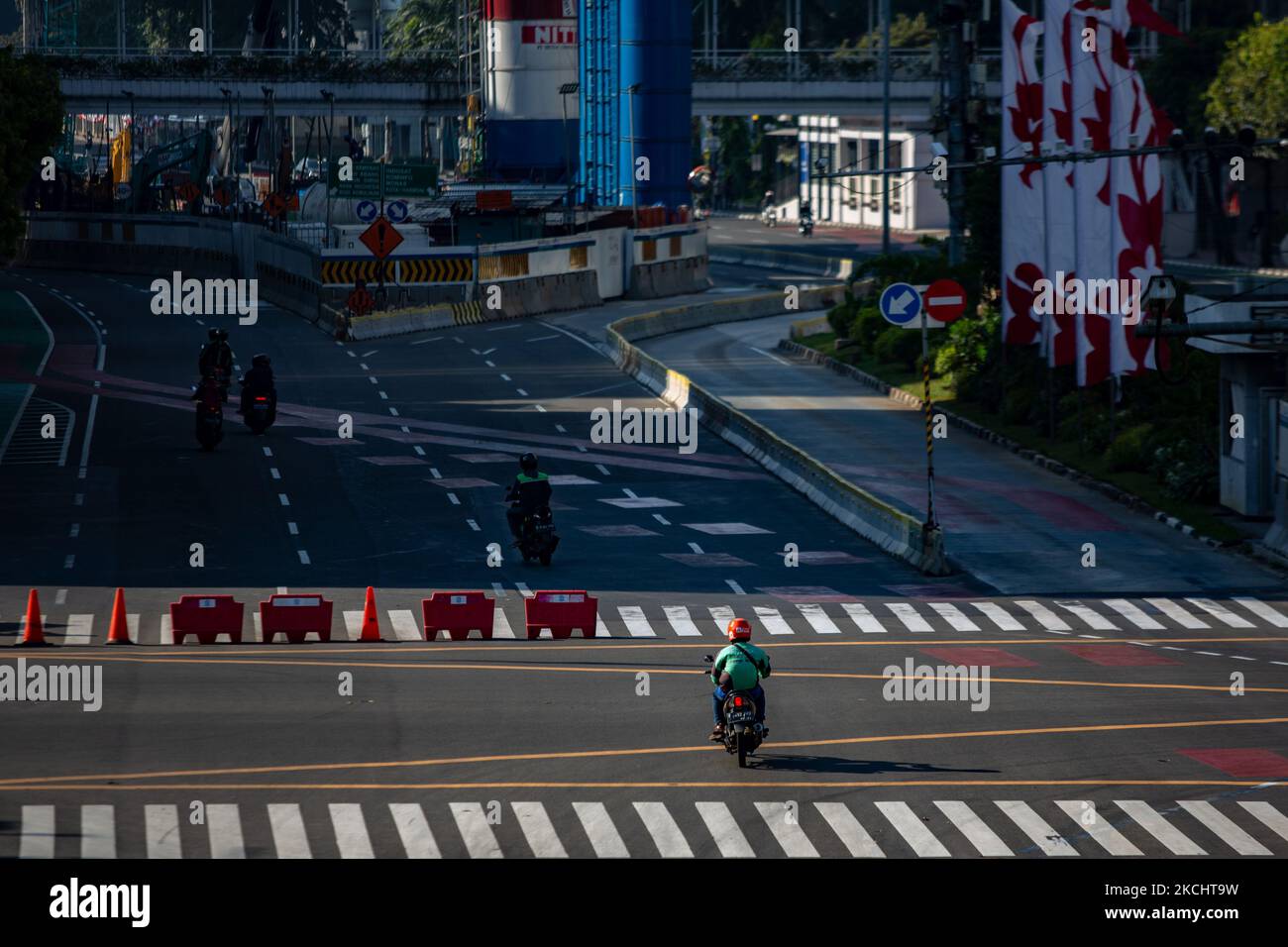Motorradfahrer versuchen, am 27. Juli 2021 eine Straßensperre in Jakarta zu passieren. Anies Baswedan, Gouverneurin von Jakarta, sagte am Dienstag, dass die in den letzten Wochen verhängte Einschränkung der öffentlichen Aktivitäten positive Ergebnisse gezeigt habe. Am Montag, den 26. Juli, gab Anies Baswedan bekannt, dass sich die aktiven Fälle in der Hauptstadt auf 64.000 reduziert haben. Am 16. Juli meldete die Stadt 113.000 aktive Fälle während des Höhepunktes der Sauerstoffkrise. Bis heute, dem 27. Juli, befinden sich rund 29.000 Jakartaner noch in der Coronavirus-Selbstisolation, 8.600 werden in Krankenhäusern behandelt, 1.400 befinden sich auf der Intensivstation (ICU) und 3.900 Menschen sind es Stockfoto