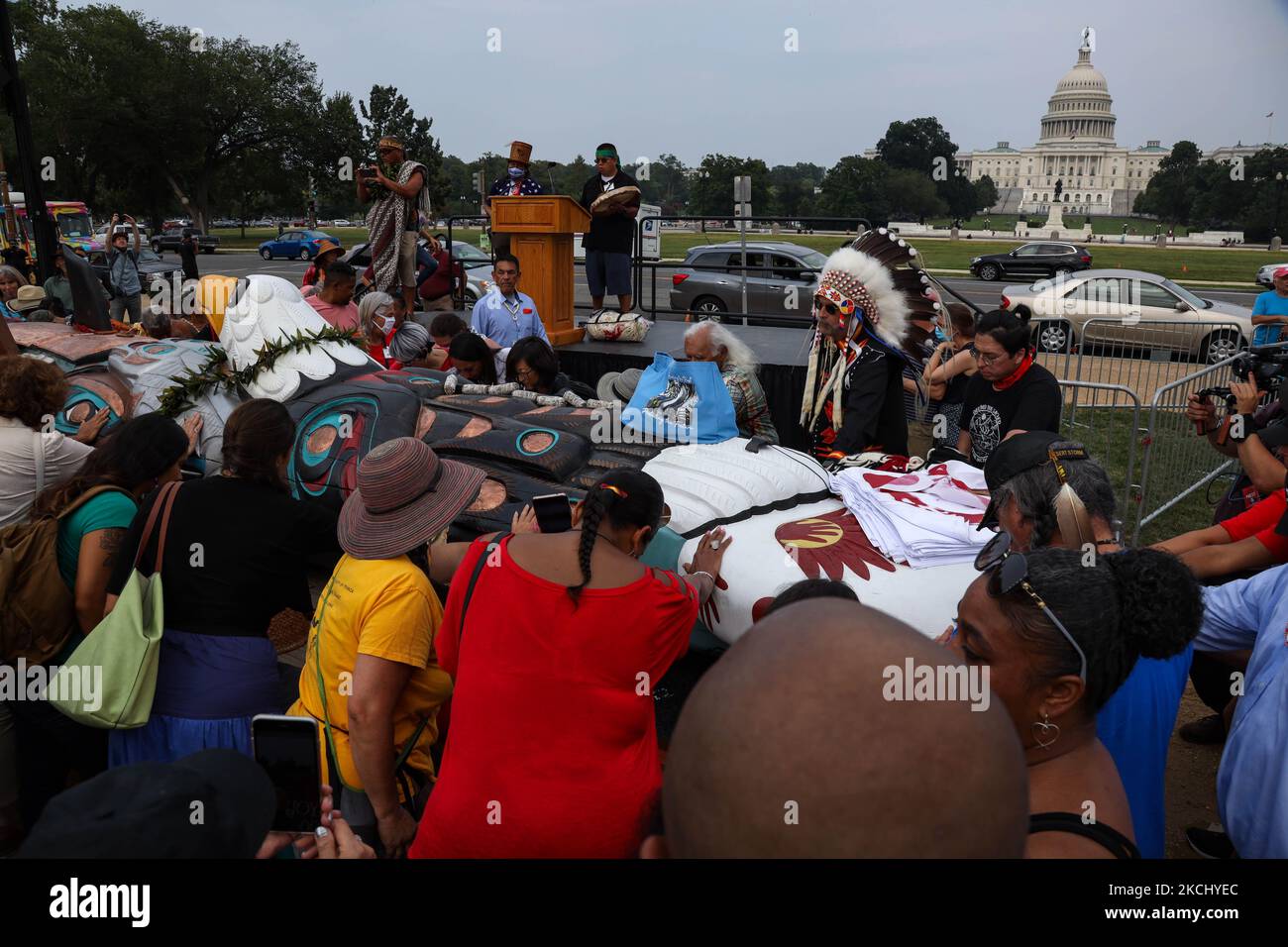 Während der Segnung der handgeschnitzten Skulptur, die vom Staat Washington nach Washington, D.C. transportiert wurde, legen die Menschen ihre Hände im Gebet auf einen Totempfahl, der am 29. Juli in der National Mall stattfand. 2021 Aufmerksamkeit und Handeln auf heilige Stätten und indigene Rechte lenken (Foto: Bryan Olin Dozier/NurPhoto) Stockfoto