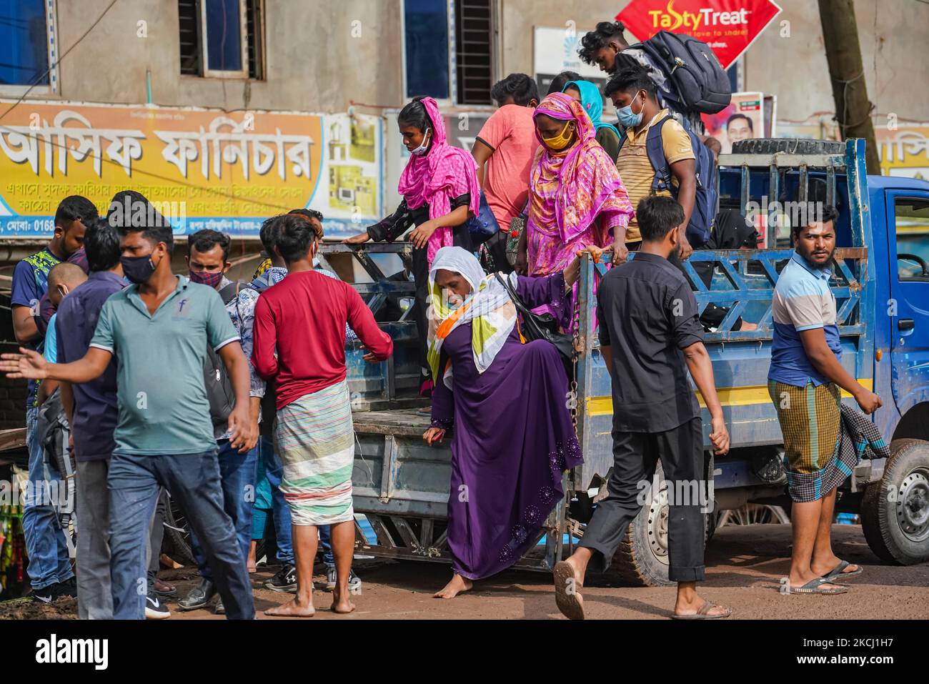 RMG und andere Arbeiter in Fertigungsbetrieben betreten Dhaka mit Pickup-LKWs während der Sperre in Dhaka, Bangladesch, am 30. Juli 2021. Die Regierung Bangladeschs lockerte die Sperrnormen für alle exportorientierten Fabriken, die früher verhängt wurden, um die Ausbreitung des Covid-19-Coronavirus einzudämmen. (Foto von Zabed Hasnain Chowdhury/NurPhoto) Stockfoto