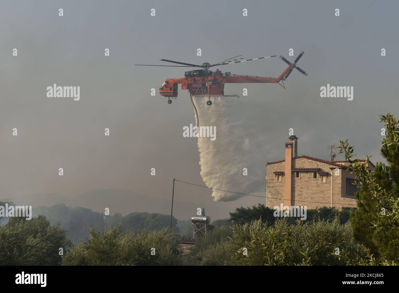 Am 4. August 2021 wird im nördlichen Vorort von Athen Varimpompi Wasser von einem feuerfesten Hubschrauber gesprüht, um ein Waldbrand zu begrenzen. (Foto von Nicolas Koutsokostas/NurPhoto) Stockfoto