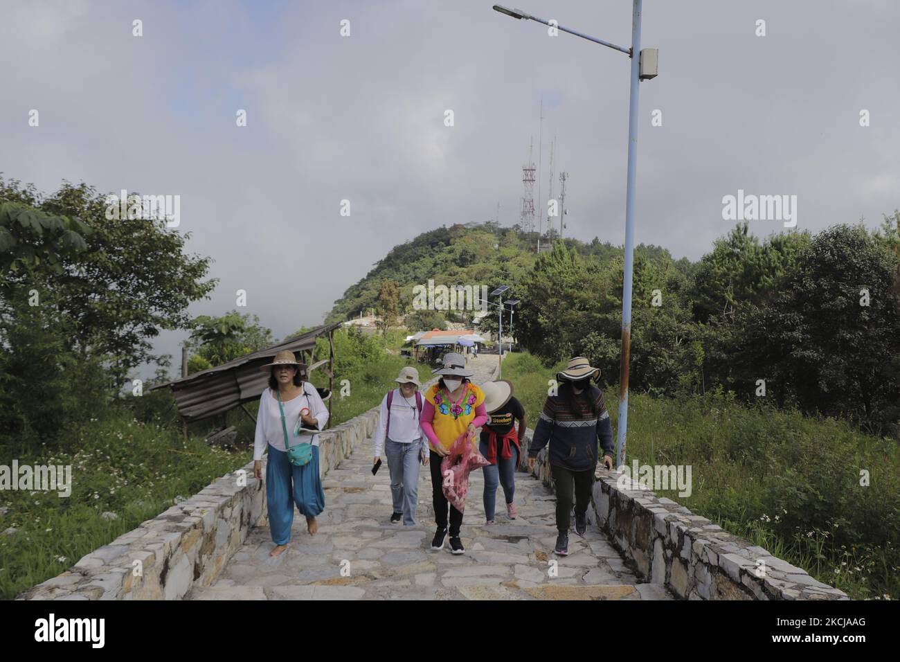 Frauen aus der Familie Campos Tamaris, die ursprünglich aus dem Tal von Mexiko stammten, besteigen den Weg des Himmlischen Kreuzes in Xicotepec de Juárez, Puebla, um an diesem Ort zu beten und Rosen zu werfen, um an ihren Vater zu erinnern, der am 5. August 2020 an COVID-19 gestorben ist. (Foto von Gerardo Vieyra/NurPhoto) Stockfoto