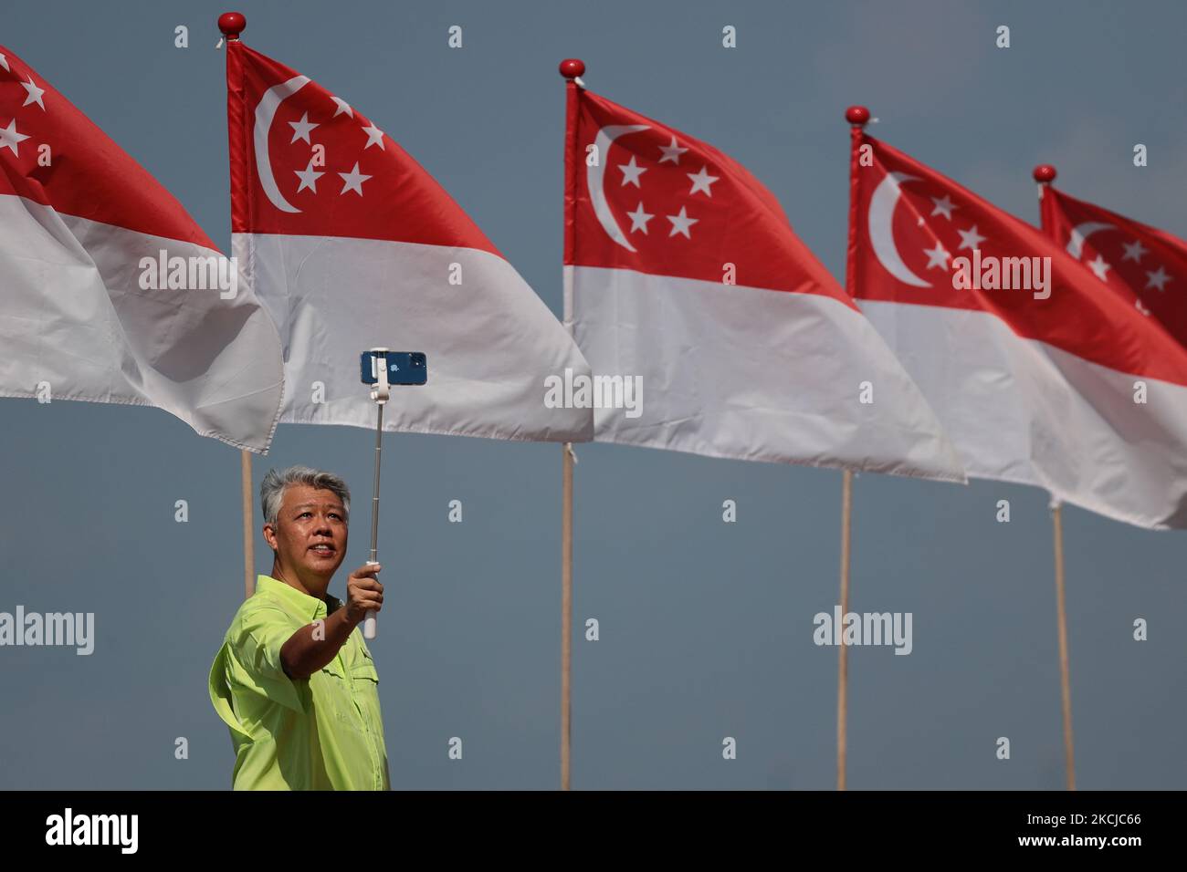 Ein Mann macht am 8. August 2021 in Singapur ein Selfie mit den Nationalflaggen Singapurs. (Foto von Suhaimi Abdullah/NurPhoto) Stockfoto