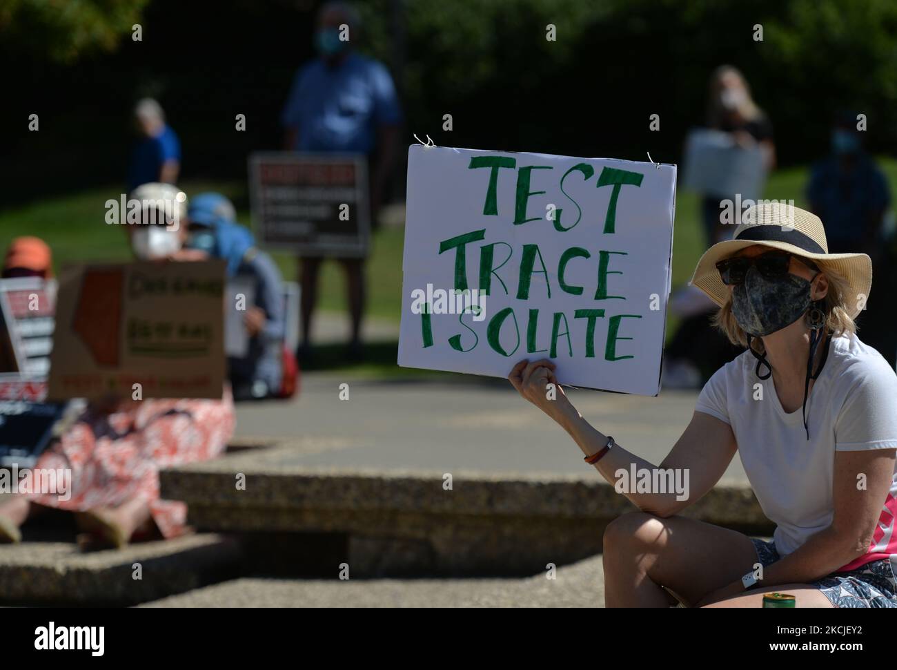 Eine Frau, die eine Gesichtsmaske trägt und ein Plakat mit der Aufschrift „Test Trace Isolate“ hält. Seit 11. Tagen in Folge protestieren Menschen gegen den Plan der Provinzregierung von Alberta, die obligatorischen COVID-19-Isolationsregeln aufzuheben, die Kontaktverfolgung und die Tests auf dem Gelände der Alberta Legislature zu verfolgen. Am Montag, den 9. August 2021, in Edmonton, Alberta, Kanada. (Foto von Artur Widak/NurPhoto) Stockfoto