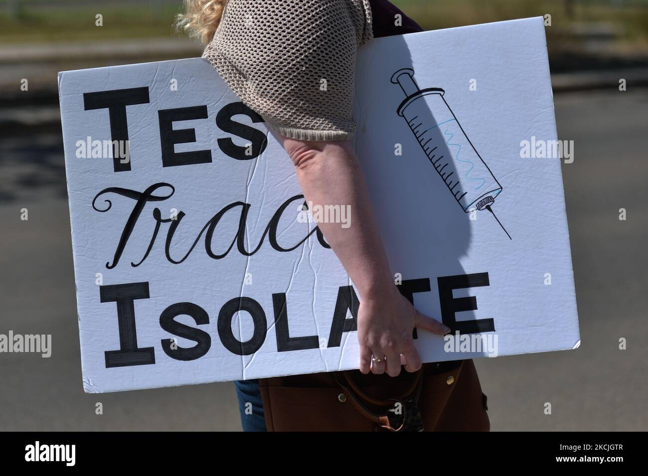 Eine Frau trägt ein Plakat mit der Aufschrift „Test Trace Isolate“, während Krankenschwestern protestieren gegen Personalmangel und staatliche Kürzungen vor dem Royal Alexandra Hospital in Edmonton. Am Mittwoch, den 11. August 2021, in Edmonton, Alberta, Kanada. (Foto von Artur Widak/NurPhoto) Stockfoto