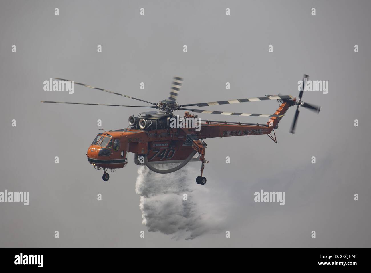 Erickson Air-Crane - Sikorsky S-64 Skycrane lässt Wasser fallen, während die Feuerwehrleute am 11. August 2021 im Dorf Galatsonas auf der griechischen Insel Evia (Euboea) ein Waldbrand bekämpfen. - Fast 100.000 Hektar Wald- und Ackerland haben in weniger als zwei Wochen in Griechenland bei der schlimmsten Waldbrandwelle seit 2007 verbrannt, sagte das Europäische Waldbrandinformationssystem (EFFIS) am Mittwoch. Stockfoto