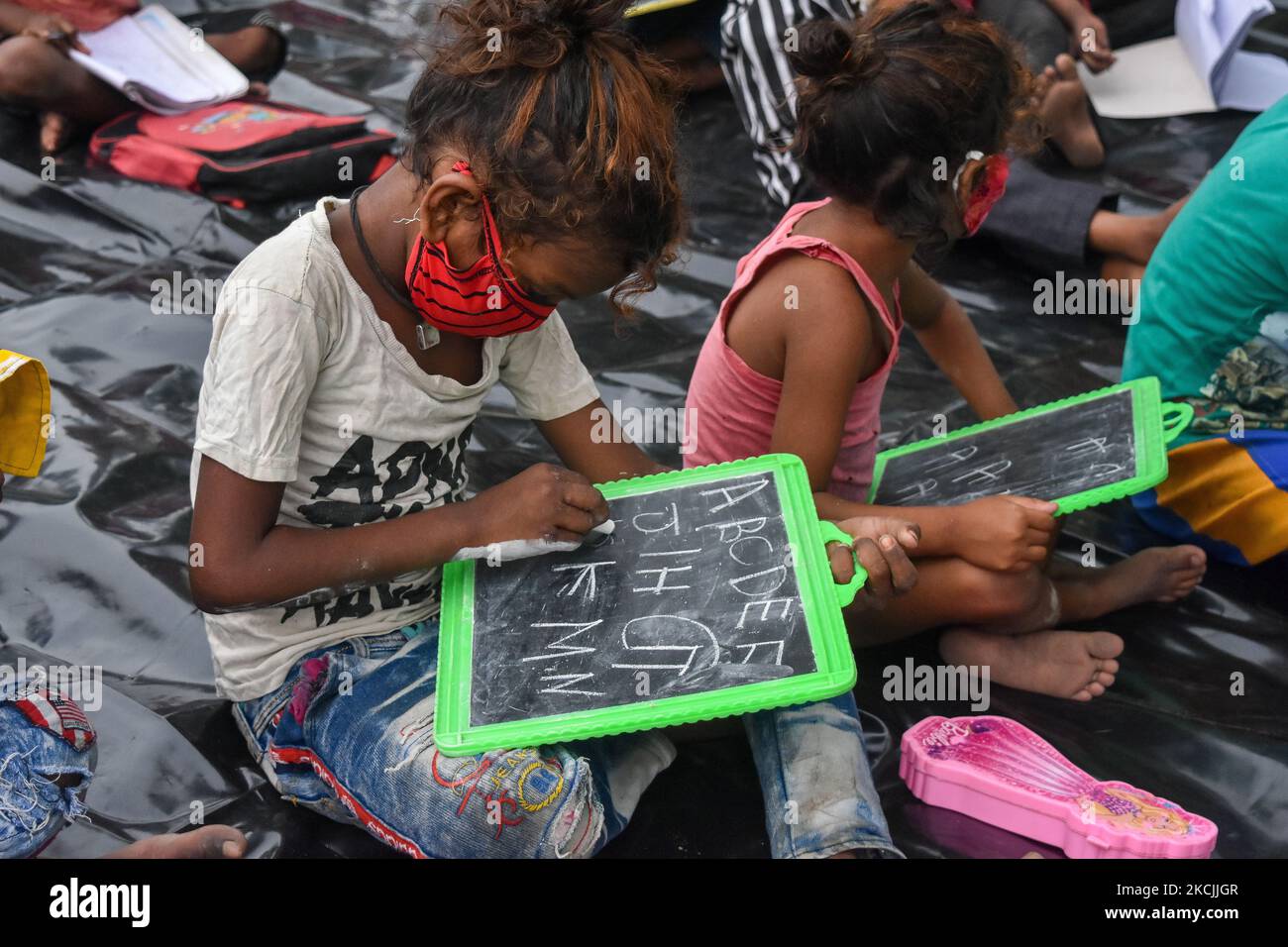 Studenten, die eine spezielle Klasse, die von South-West Traffic Guard organisiert wurde, um kostenlose Bildung für Kinder mit Wohnsitz in Slum Gebieten bieten , in Kalkutta , Indien , am 13. August 2021 . Eine spezielle Klasse wurde von der südwestlichen Verkehrswache für Studenten aus Slums im Süden von Kalkutta organisiert, die keine Online-Kurse oder -Schulungen in Anspruch nehmen können, da alle Schulen wegen der Pandemie geschlossen bleiben. (Foto von Debarchan Chatterjee/NurPhoto) Stockfoto