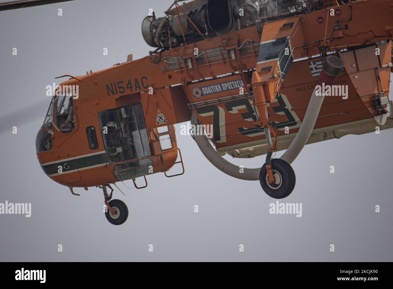 Erickson Air-Crane - Sikorsky S-64 Skycrane lässt Wasser fallen, während die Feuerwehrleute am 11. August 2021 im Dorf Galatsonas auf der griechischen Insel Evia (Euboea) ein Waldbrand bekämpfen. - Fast 100.000 Hektar Wald- und Ackerland haben in weniger als zwei Wochen in Griechenland bei der schlimmsten Waldbrandwelle seit 2007 verbrannt, sagte das Europäische Waldbrandinformationssystem (EFFIS) am Mittwoch. Stockfoto