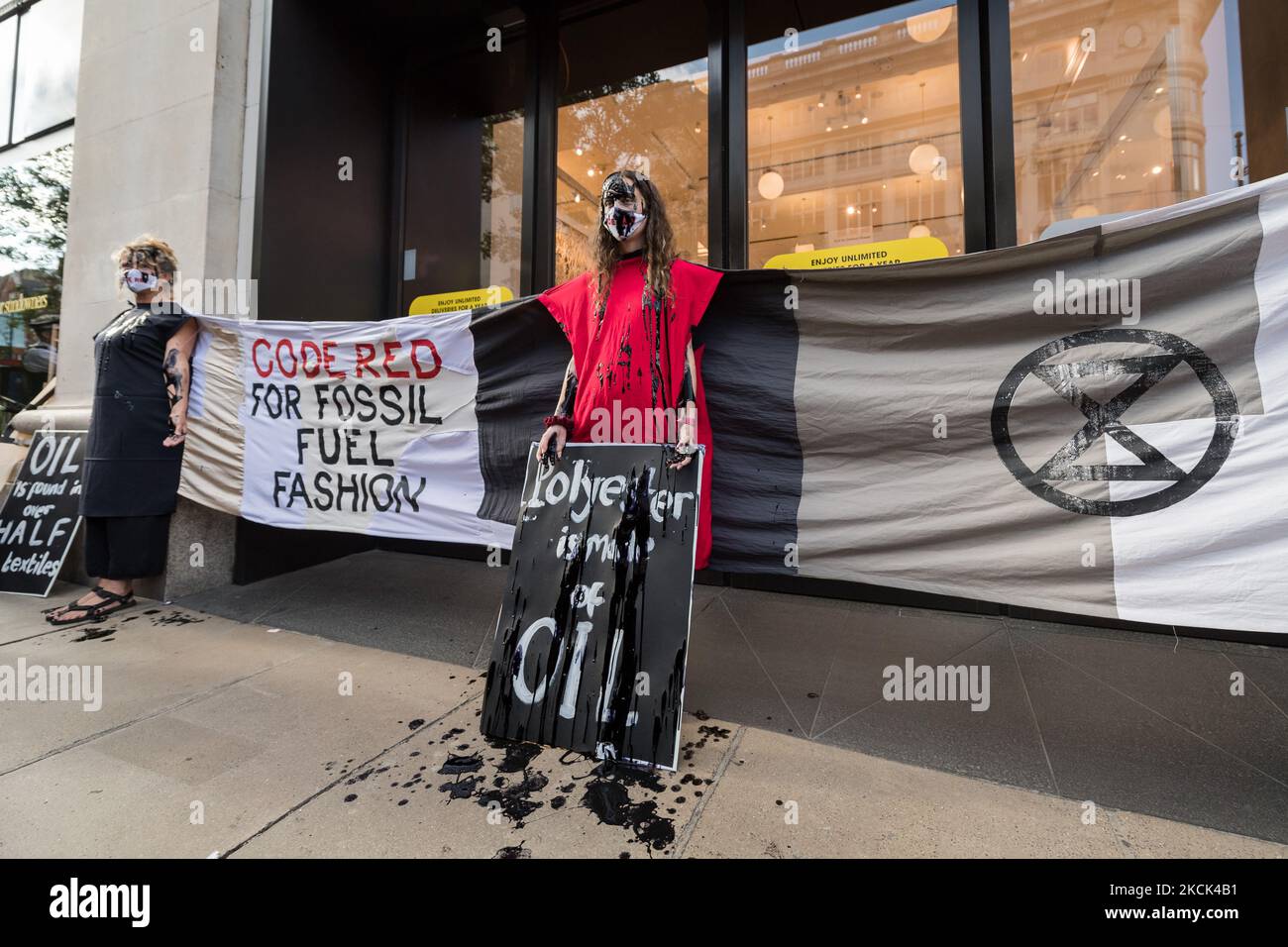 LONDON, GROSSBRITANNIEN - 24. AUGUST 2021: Umweltaktivisten vom Aussterben am 24. August 2021 protestieren die Rebellion vor dem Kaufhaus Selfridges in der Oxford Street gegen die Abhängigkeit der Modeindustrie von synthetischen Polyester- und Nylontextilien aus Erdöl in der Klimakrise und in der ökologischen Notlage in London, England. (Foto von Wiktor Szymanowicz/NurPhoto) Stockfoto