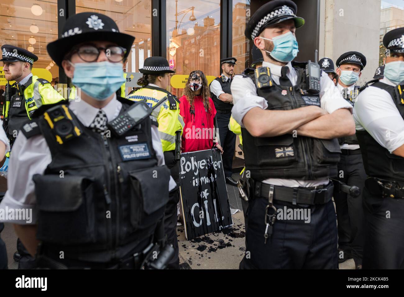 LONDON, GROSSBRITANNIEN – 24. AUGUST 2021: Umweltaktivisten des Extinction Rebellion sind von Polizeibeamten umgeben, als sie am 24. August 2021 in London, England, vor dem Kaufhaus Selfridges in der Oxford Street gegen das Vertrauen der Modeindustrie auf synthetische Polyester- und Nylontextilien aus Erdöl protestieren. (Foto von Wiktor Szymanowicz/NurPhoto) Stockfoto