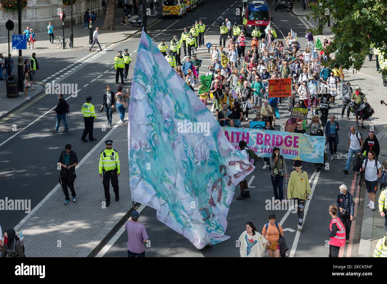 LONDON, VEREINIGTES KÖNIGREICH - 25. AUGUST 2021: Umweltaktivisten vom Extinction Rebellion marschieren am dritten Tag des 'Impossible Rebellion' durch das Zentrum Londons, Eine neue Welle von Protesten und zivilen Ungehorsamsmaßnahmen, die mindestens zwei Wochen andauern soll, um einen sofortigen Stopp aller neuen Investitionen in fossile Brennstoffe durch die britische Regierung und Finanzkonzerne zu fordern, inmitten der Klimakrise und der ökologischen Notlage am 25. August 2021 in London, England. (Foto von Wiktor Szymanowicz/NurPhoto) Stockfoto